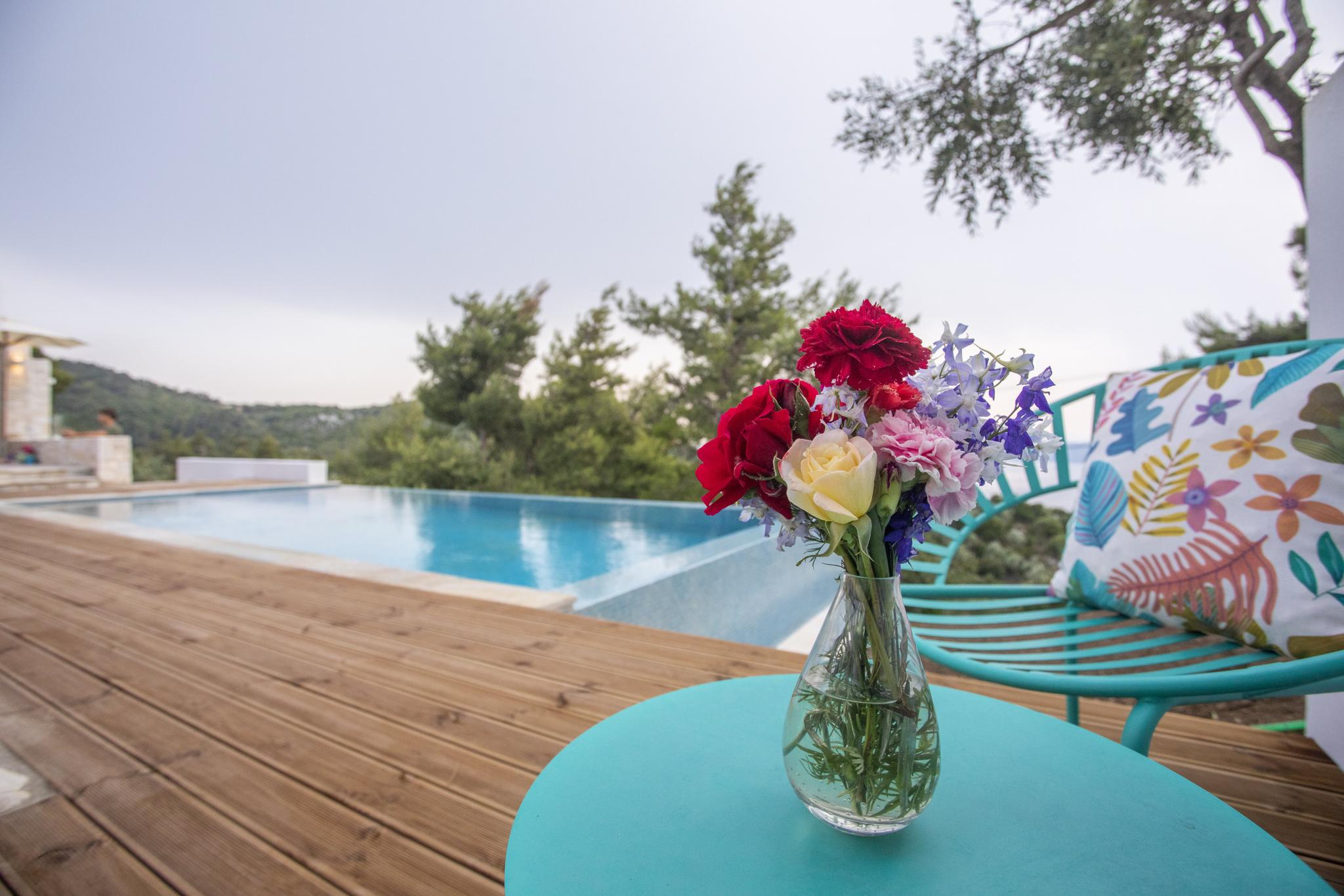 Lush Mediterranean flowers and pine trees at a luxury villa in Skiathos Greece during early summer June